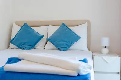 a blue and white bed with blue pillows and a white at Guest House Vucicevic in Budva
