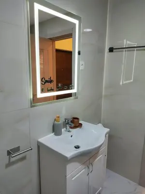 a white bathroom with a sink and a mirror at Apartments Sunny in Becici
