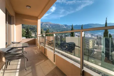 a balcony with a table and chairs and a view at Apartments Location by Chabad House in Becici