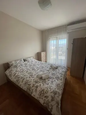 a bedroom with a bed with two towels on it at Sunny Corner Apartment in Podgorica