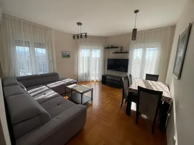 a living room with a couch and a table at Sunny Corner Apartment in Podgorica