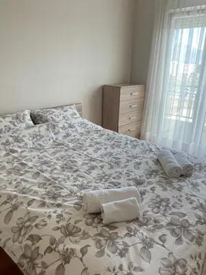 a bedroom with a large bed with towels on it at Sunny Corner Apartment in Podgorica