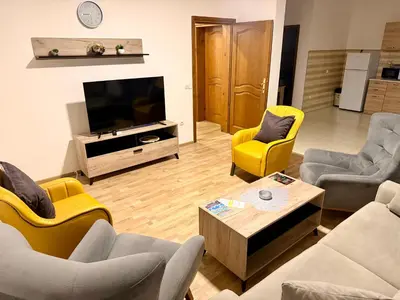 a living room with yellow chairs and a television at M apartment 3 in Bar