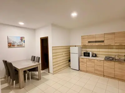 a kitchen with a wooden table and a table and chairs at M apartment 3 in Bar