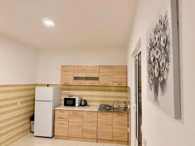a kitchen with wooden cabinets and a white refrigerator at M apartment 3 in Bar