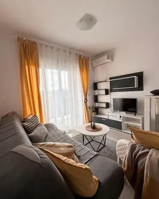 a living room with a couch and a tv at Cozy seaside studio in Bar
