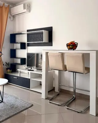 a white desk with two chairs and a tv at Cozy seaside studio in Bar