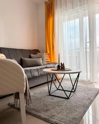 a living room with a table and a couch at Cozy seaside studio in Bar