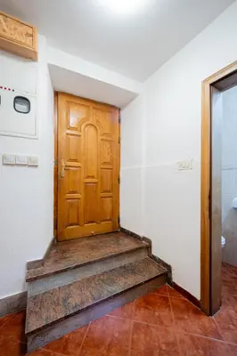 a hallway with a wooden door and stairs at Tara Rooms In The Heart Of Old Town Kotor in Kotor