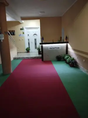 a red white and green carpet in a room with a reception at Grandino Rooms & Apartments in Ulcinj