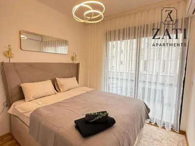 a bedroom with a large bed with a large window at Zati Homes Ulcinj in Ulcinj