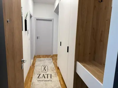 a small hallway with a door and a rug at Zati Homes Ulcinj in Ulcinj
