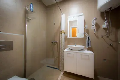 a bathroom with a shower and a sink and a mirror at Posh Residence Podgorica in Podgorica