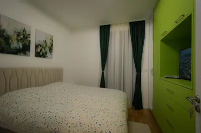 a bedroom with a bed and a green door at Posh Residence Podgorica in Podgorica
