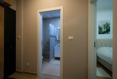 a room with a bathroom with a toilet and a bed at Posh Residence Podgorica in Podgorica