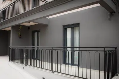 a balcony of a building with a black railing at Posh Residence Podgorica in Podgorica