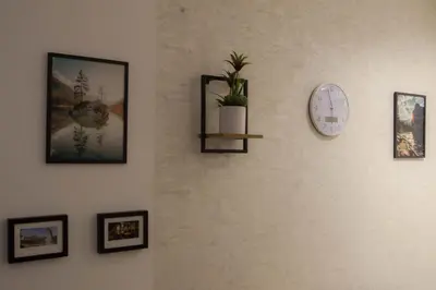 a wall with a clock and pictures on it at Posh Residence Podgorica in Podgorica