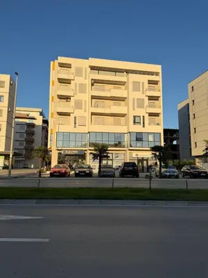 a large building with cars parked in a parking lot at Lindi in Ulcinj