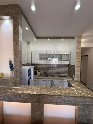 a large kitchen with white cabinets and a counter top at Lindi in Ulcinj