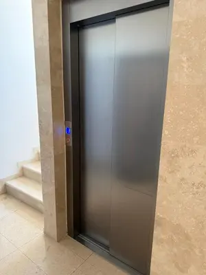 a metal elevator door in a building with stairs at Lindi in Ulcinj