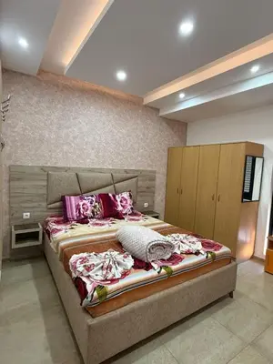 a bedroom with a large bed with pink pillows at Lindi in Ulcinj