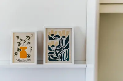 two framed prints of flowers on a shelf at The View - Apartment with Pool in Blizikuće
