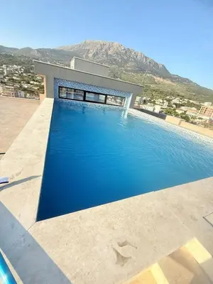 a swimming pool in front of a house at Apartment Hrubosovic Dobra voda in Dobra Voda
