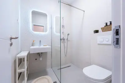 a bathroom with a shower and a toilet and a sink at Quince Apartments in Podgorica