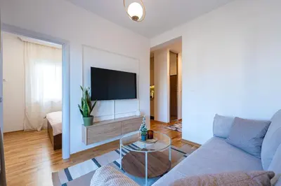 a living room with a couch and a tv at Quince Apartments in Podgorica