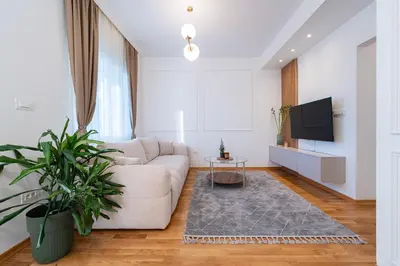 a living room with a couch and a tv at Quince Apartments in Podgorica