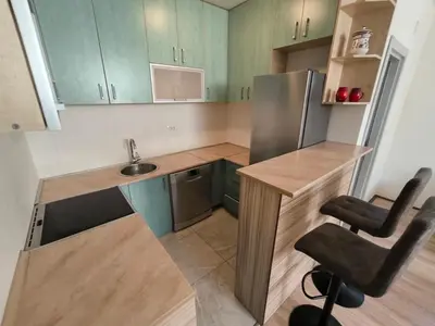 a small kitchen with green cabinets and a stainless steel refrigerator at Stex Signature Central Point in Podgorica