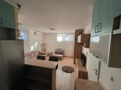 a small living room with a couch and a kitchen at Stex Signature Central Point in Podgorica