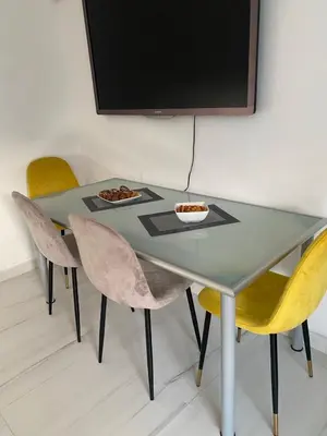 a table with chairs and a television on a wall at Apartman sa garažom in Sutomore