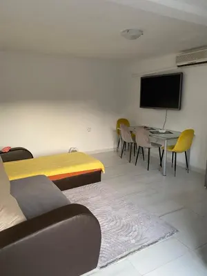 a room with a table and chairs and a flat screen tv at Apartman sa garažom in Sutomore