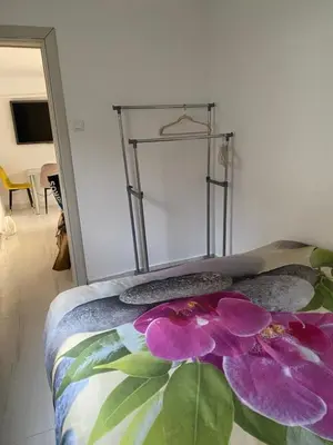 a bed with a purple flower on it in a room at Apartman sa garažom in Sutomore