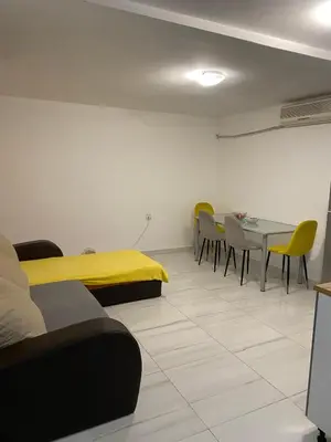 a room with two beds and a table and chairs at Apartman sa garažom in Sutomore