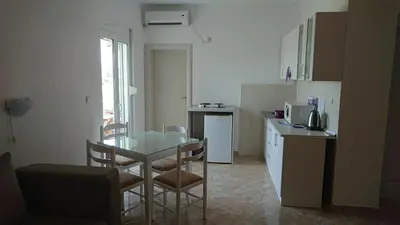 a kitchen with a glass table and chairs in a room at Luce di Sole Apartment in Ulcinj