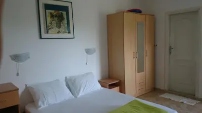 a bedroom with a white bed and a cabinet at Luce di Sole Apartment in Ulcinj