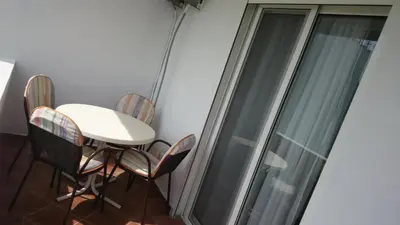 a table and chairs in a room with a window at Luce di Sole Apartment in Ulcinj