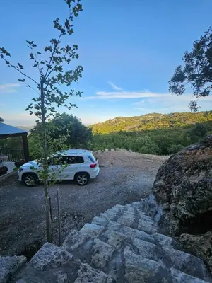 a white car parked in a gravel parking lot at Village Drago in Cetinje