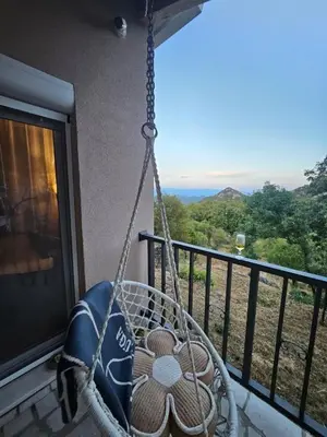 a swing on a balcony with a view of the mountains at Village Drago in Cetinje