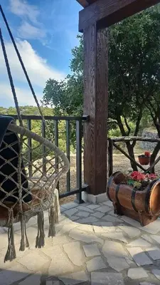 a porch with a swing and a flower planter at Village Drago in Cetinje