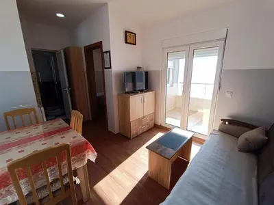 a living room with a bed and a tv at Apartmani Šaltić in Sutomore