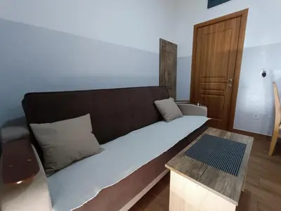 a room with a bed and a table in it at Apartmani Šaltić in Sutomore