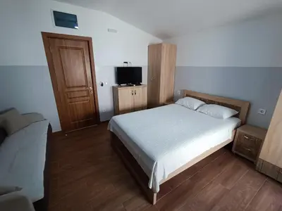 a bedroom with a white bed and a television at Apartmani Šaltić in Sutomore