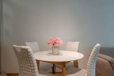 a table with chairs and a vase of flowers on it at Apartment Pržno See View in Pržno