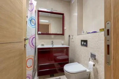 a bathroom with a toilet and a sink and a mirror at Apartment Pržno See View in Pržno