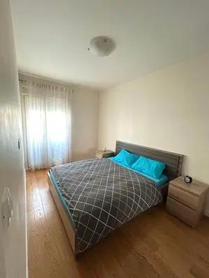 a bedroom with a bed with blue pillows and a window at Elegant apt in Central Point in Podgorica
