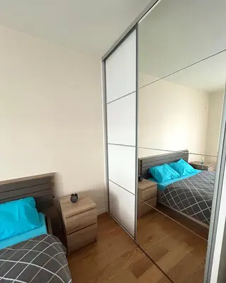 a bedroom with two beds and a mirror at Elegant apt in Central Point in Podgorica