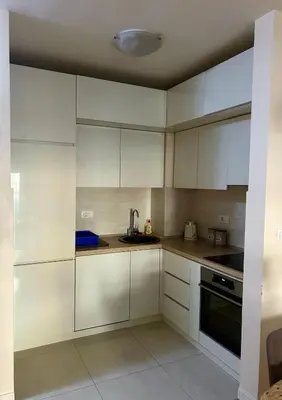 a white kitchen with white cabinets and a sink at Elegant apt in Central Point in Podgorica